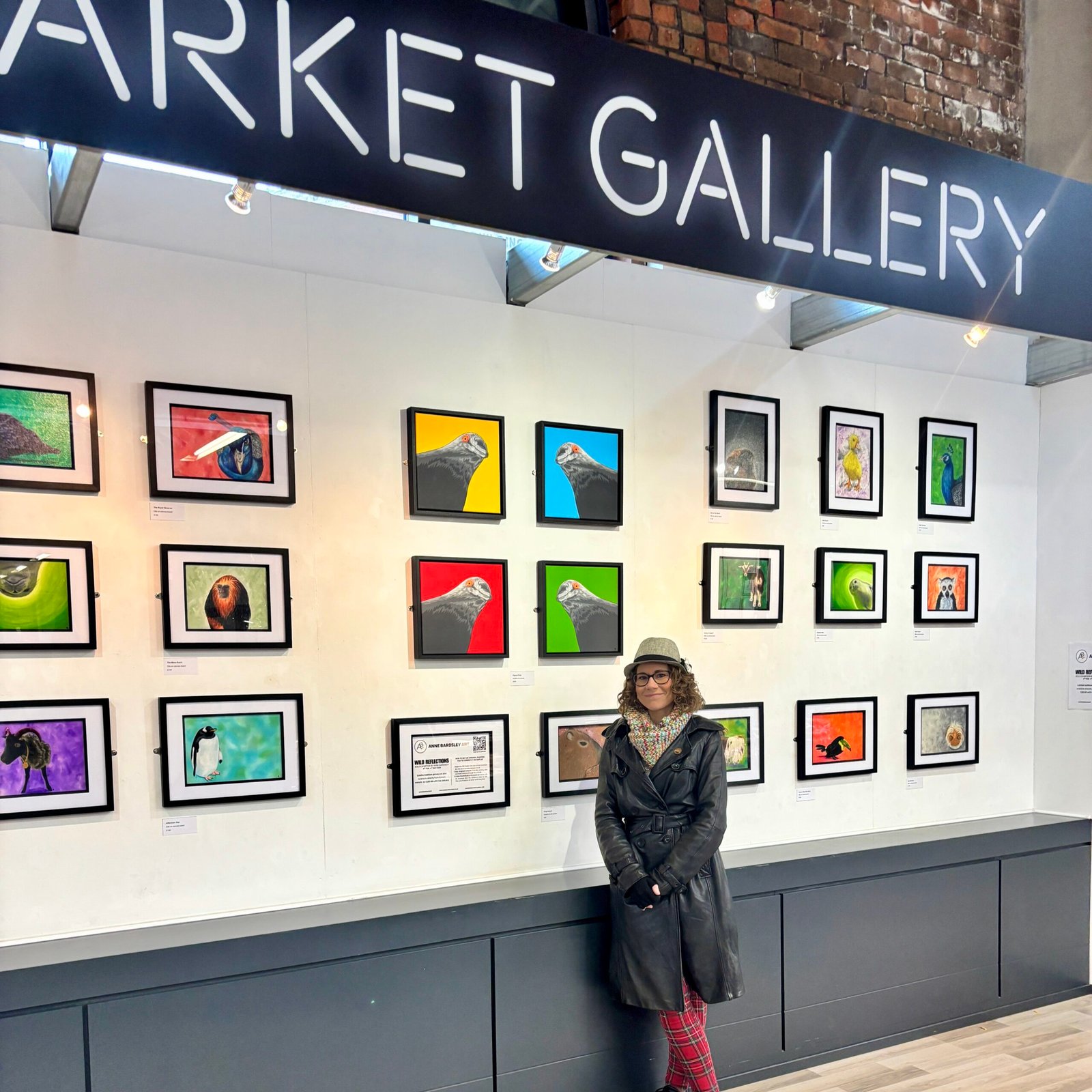 Anne Bardsley Art Wild Reflections Exhibition Featuring Feb 2026 Anne Bardsley Stood In Front Of A Wall Of Framed Paintings