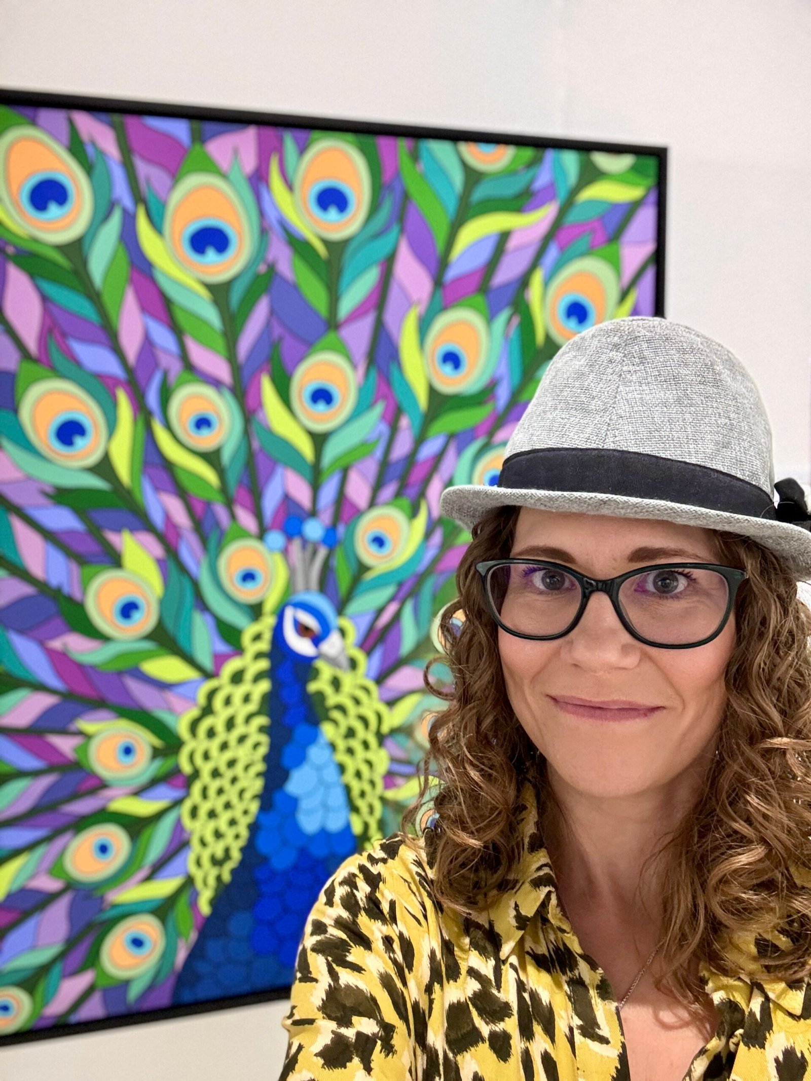 Anne Bardsley next to peacock painting